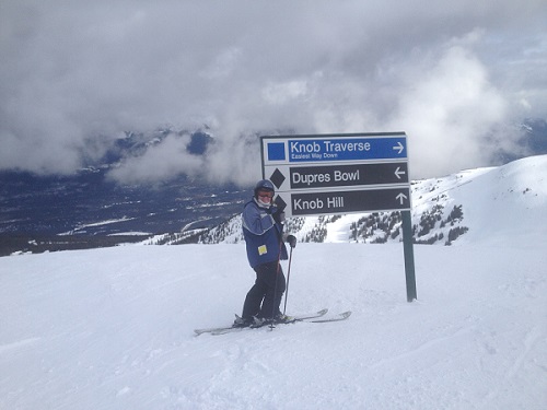 Skiing in front of trail sign